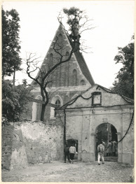 Kościół parafialny  - widok od strony płd. - zach. na fasadę kościoła, bramę i fragment muru, skan 1