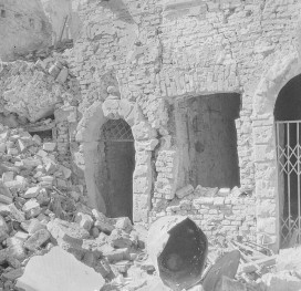 Zniszczona kamienica. Fragment z wejściem do kamienicy., skan 1