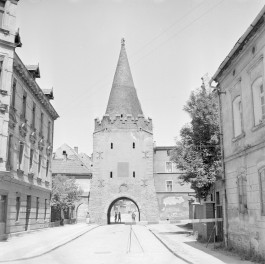 Brama Paczkowska.Górna część wieży zwieńczona jest krenelażem (zębatym zwieńczeniem murów), nad którym wznosi się wysoki, stożkowy dach pokryty dachówką. Smukły hełm zakończony jest ozdobnym zwieńczeniem. Całość nadaje budowli charakter typowej wieży bramnej o funkcji obronnej i kontrolnej. Brama wkomponowana jest w ciąg zabudowy miejskiej – po obu stronach znajdują się kamienice o elewacjach z przełomu XIX i XX wieku. Ulica prowadzi bezpośrednio pod łuk przejazdu, a w tle widoczne są kolejne zabudowania., skan 1