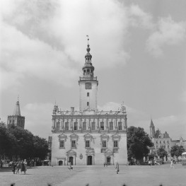 Ratusz - elewacja frontowa. Trzy kondygnacje. Widoczne 3 portale. Dwa posiadają trójkątne naczółki. Główny posiada relief i kartusz. na szczycie arkada. Bogato zdobiona attyka na wysokości drugiego piętra. Boniowany fryz, rząd ozdób w postaci sterczyn, szczycików i wolut. Wieża zdobiona boniowaniem. Zegar na wieży i nakryta tarasem widokowym kamienna balustrada., skan 1