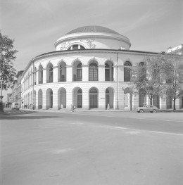 Gmach Giełdy i Banku Polskiego w Warszawie, zaprojektowany przez Antonia Corazziego i wzniesiony w latach 1825–1828. Wielka rotunda nakryta kopułą, widoczna w górnej części budynku. To główny akcent kompozycyjny i zarazem element, który od razu odróżnia ten gmach od zwykłej zabudowy miejskiej. Poniżej kopuły biegnie półkolista elewacja z wyraźnym, klasycystycznym porządkiem architektonicznym. Środkowa kondygnacja została ukształtowana jako ciąg arkad. Wysokie, półkoliście zamknięte otwory tworzą rytmiczną galerię, bardzo elegancką i reprezentacyjną. Jeszcze niżej znajduje się przyziemie z kolejnym pasem arkad, cięższe i bardziej masywne, dzięki czemu cała bryła ma solidną podstawę. Dekorację rzeźbiarską nad wielkim otworem okiennym — motywy alegoryczne lub ornamentalne, które podkreślają reprezentacyjny charakter budynku. , skan 1